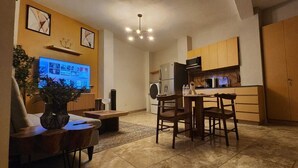 A compact living space with a dining area, kitchen, and a TV mounted on the wall. - Apartment in downtown San Jose del Cabo on the transpeninsular highway. (San José del Cabo)