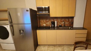 A compact kitchen with a stainless steel refrigerator, a microwave, a coffee maker, and a sink. - Apartment in downtown San Jose del Cabo on the transpeninsular highway. (San José del Cabo)