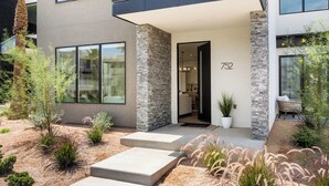 A modern two-story house with a stone facade, numbered 752, featuring a covered entryway and a landscaped garden with various plants. - Sunstone Retreat: Hot Tub + Desert Color Lagoon + Beaches, Hot Tub (St. George)