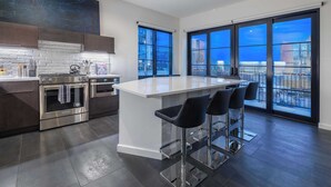A modern kitchen with a central island, stainless steel appliances, and large windows offering city views. - 121 Hotel Buyout by Avantstay Buyout of 121 Hotel w/ Living Areas & Meeting Room! Sleeps 58 (Nashville)