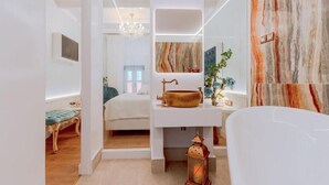 A modern bathroom with a marble backsplash, a white vanity, and a hanging light fixture. - Madame Hortense Hotel (Chania)