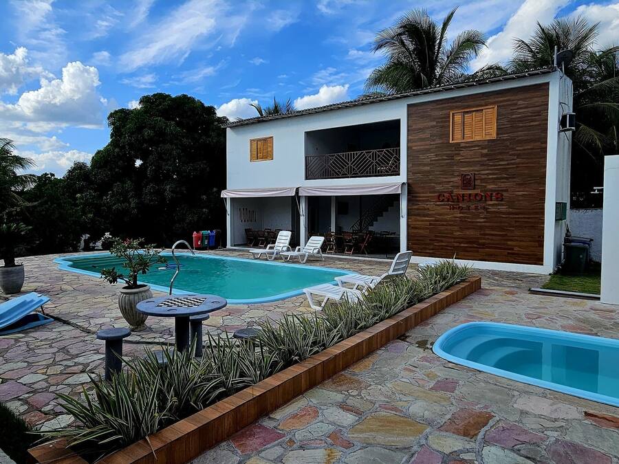 Um hotel com área de piscina, incluindo espreguiçadeiras e uma pequena mesa.