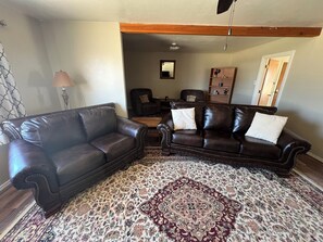 Relax in this inviting living room with a comfortable sofa, area rug, and bookshelf.
