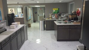 Una cucina moderna con pavimento in marmo, elettrodomestici in acciaio inossidabile e un'organizzazione pulita ed efficiente.