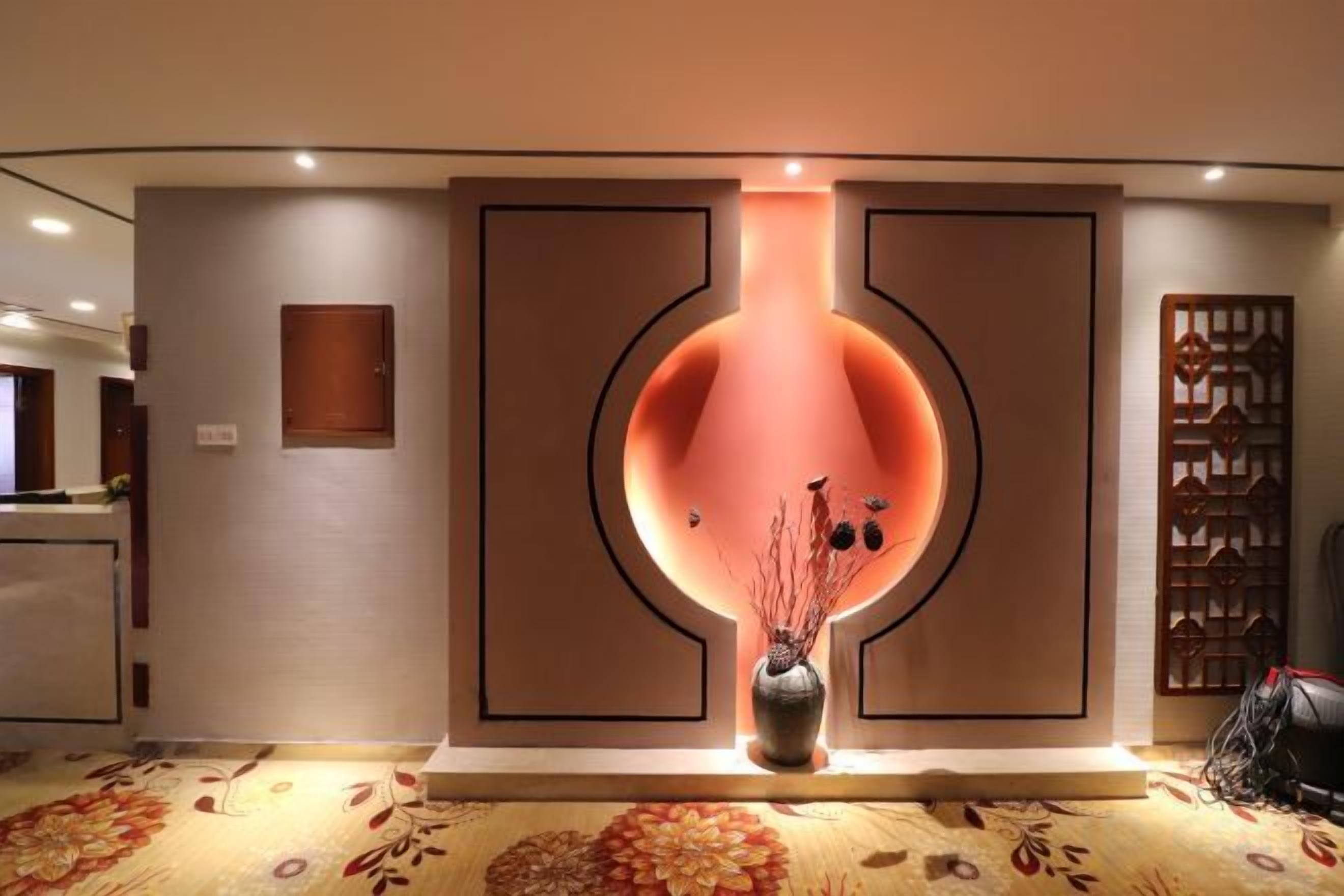 A reception area with a modern design, a vase with branches, and a patterned carpet.