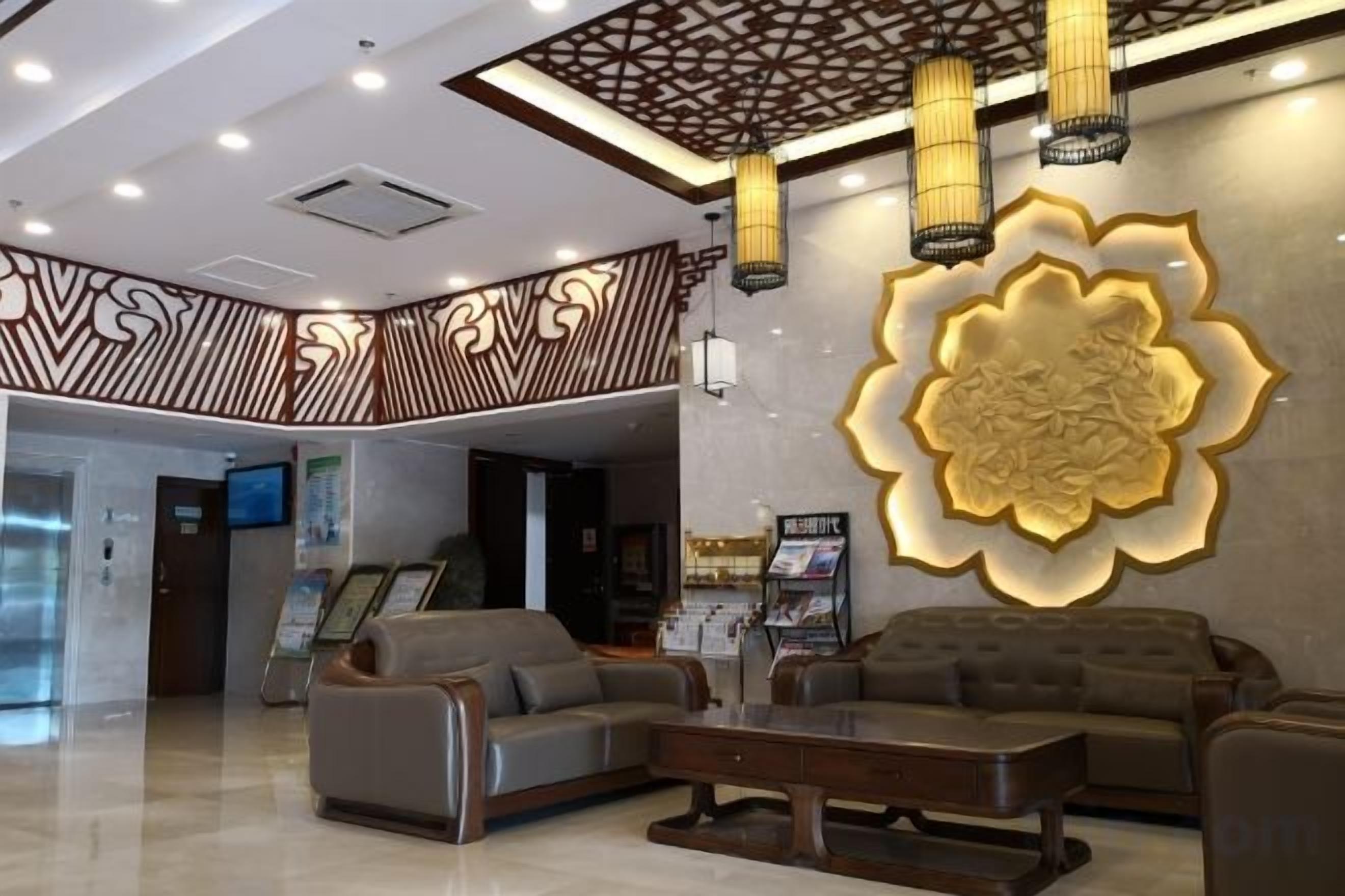 A lobby with a reception desk, seating area, and a large decorative wall.
