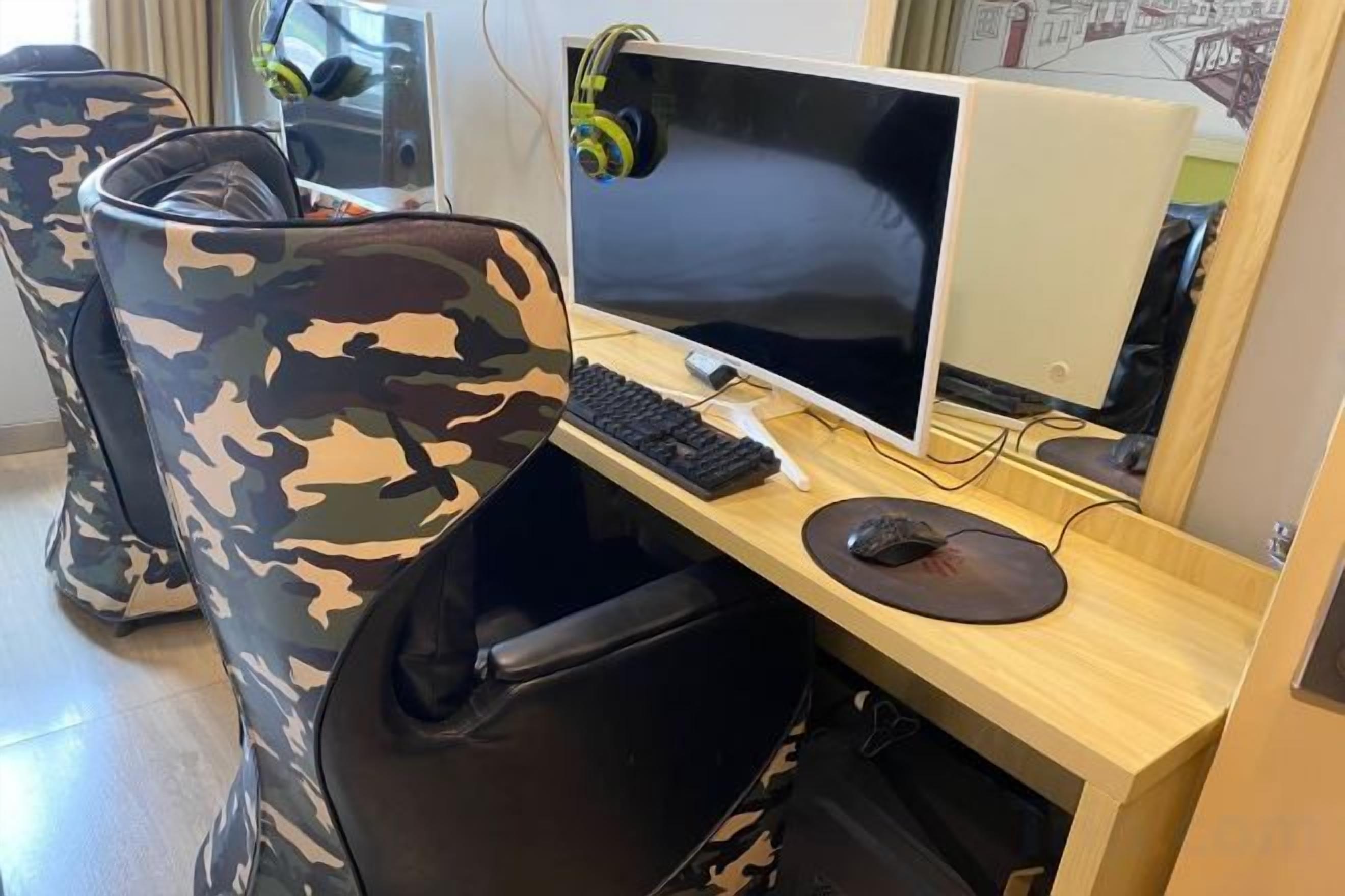 A room with a computer desk, a chair, and a pair of headphones.