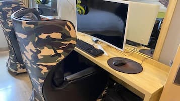 A room with a computer desk, a chair, and a pair of headphones.