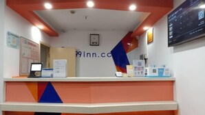 A reception desk with a computer, informational posters, and a sign with the website 99inn.com. - 99 Inn (Shanghai Songjiang University Town) (Shanghai)