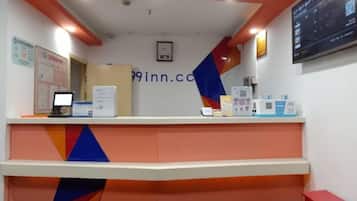 Una recepción de hotel con una computadora, un teléfono y folletos informativos.
