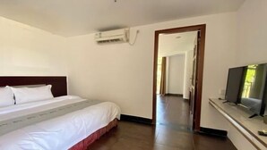 A hotel room with a bed, a television, and an air conditioning unit. - Haixuan Hotel (Taishan)
