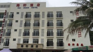A multi-story hotel with balconies on each floor, a sign indicating it is the Hai Xuan Hotel, and a visible entrance with a covered area in front. - Haixuan Hotel (Taishan)
