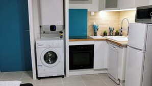 Cocina compacta equipada con lavadora, lavavajillas y microondas.