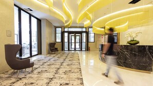 A modern lobby with a marble floor, a reception desk, and a large window. - Charlie  Lumiere Klabin (São Paulo)