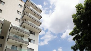 A swimming pool with a clear blue water, surrounded by a tiled deck. - TCC APARTMENT (Accra)