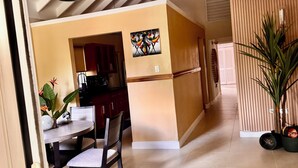 A modern kitchen with a dining area, featuring a dining table, chairs, and a potted plant. - Tropical Tranquility in Jamaica (Richmond Estate)