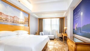 A hotel room with a large bed, a desk, a chair, and a television. - Vienna International Hotel (Zhuzhou Railway Station Central Square Branch) (Zhuzhou)