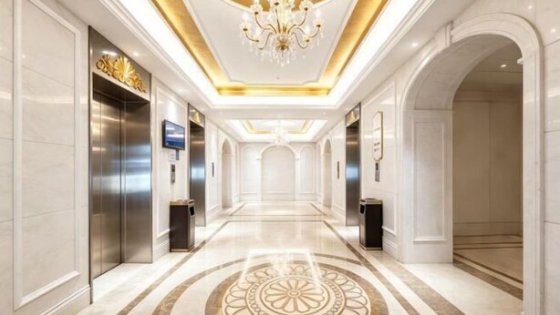 A hotel corridor with a chandelier, elevators, and a patterned floor. - Vienna International Hotel (Zhuzhou Railway Station Central Square Branch) (Zhuzhou)