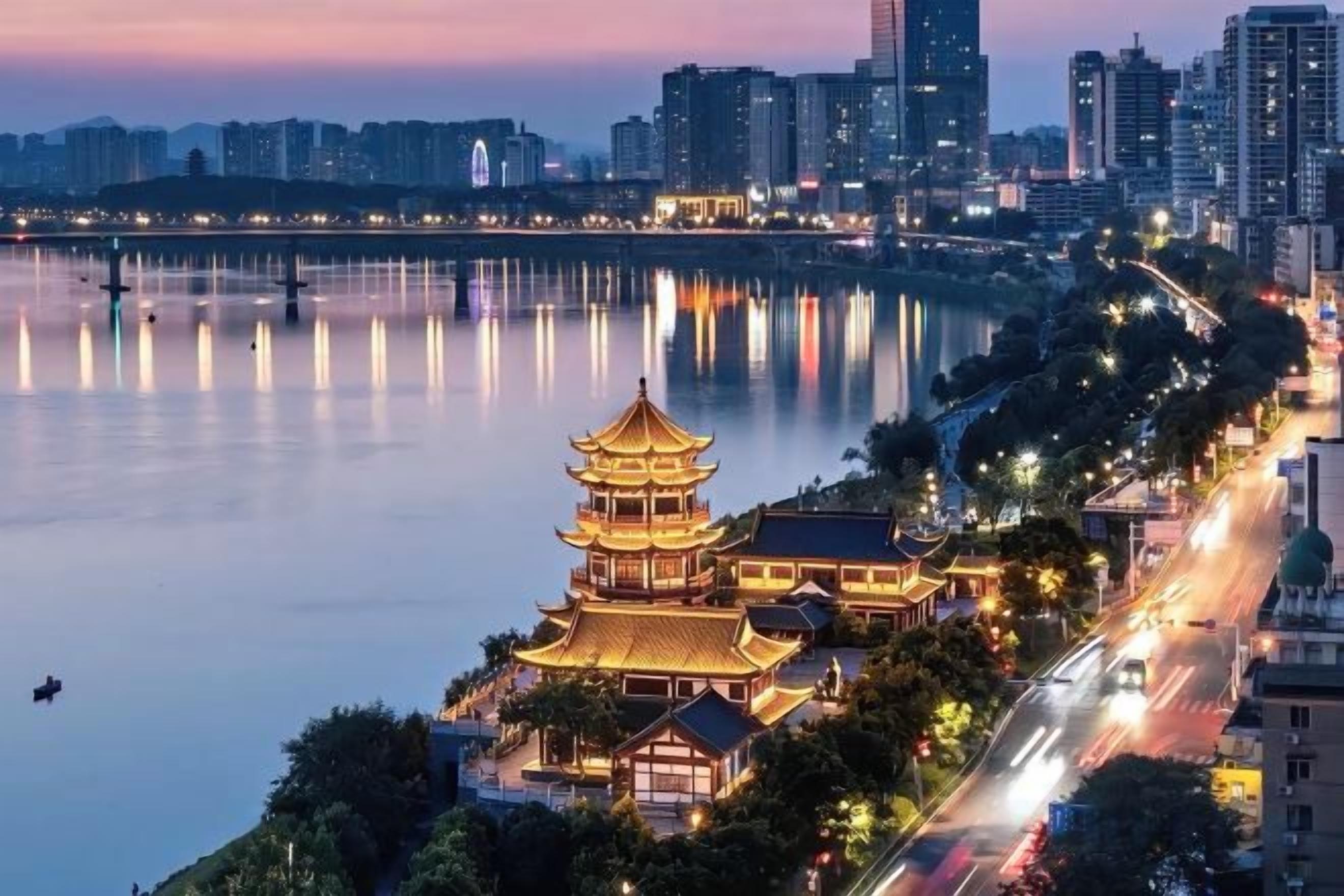 Un edificio tradicional de estilo pagoda con varios niveles, ubicado junto a un muelle con un horizonte urbano de fondo.