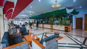 A hotel lobby with seating areas, a reception desk, and potted plants. - Mazafran Zeralda (Algiers)