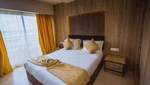 A hotel room with a large bed, wooden headboard, and a small bedside table. - Mazafran Zeralda (Algiers)
