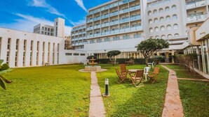 A hotel courtyard with a central fountain, outdoor seating, and a large building with multiple balconies. - Mazafran Zeralda (Algiers)