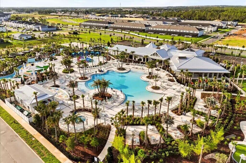 Ein Resort mit mehreren Schwimmbecken, Palmen und einem großen Gebäudekomplex.