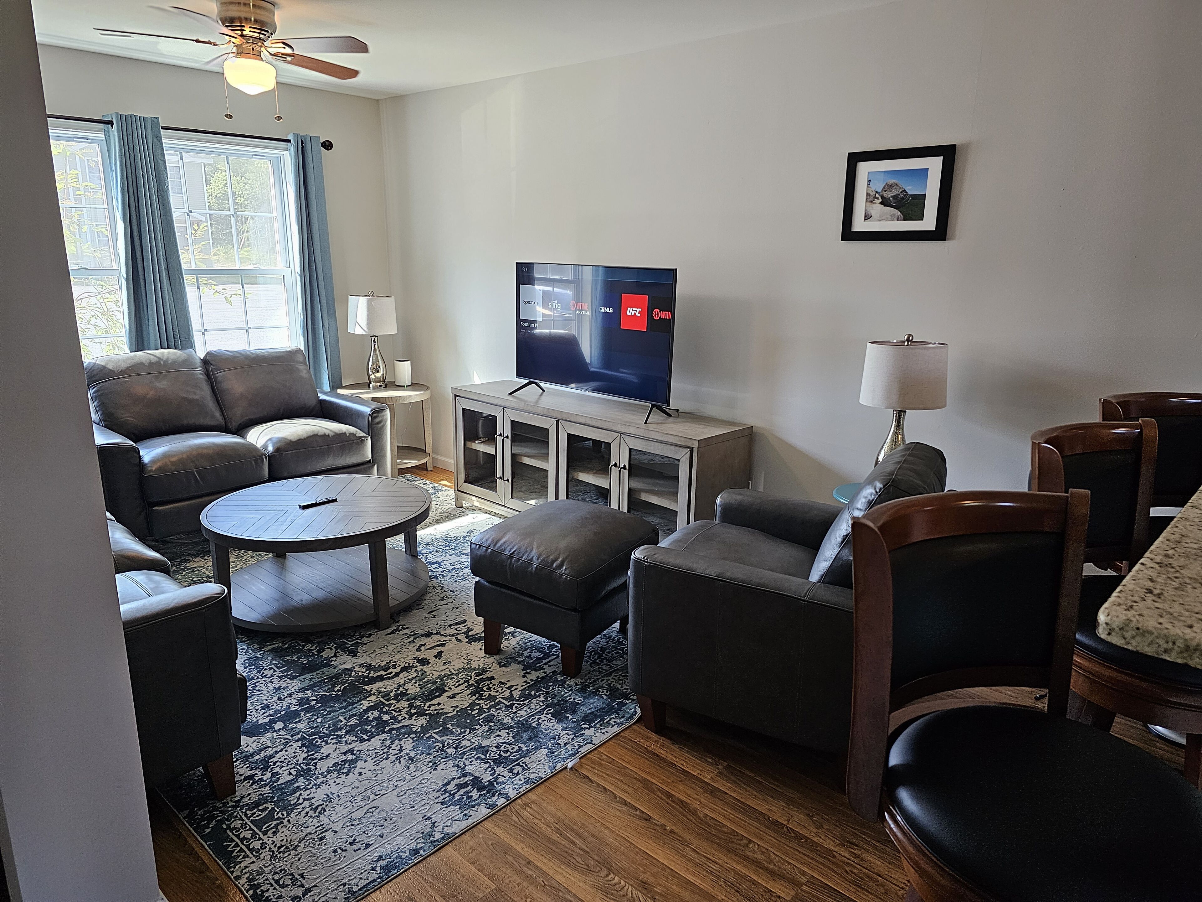 A living room with a sofa set, a coffee table, a TV, and a rug.