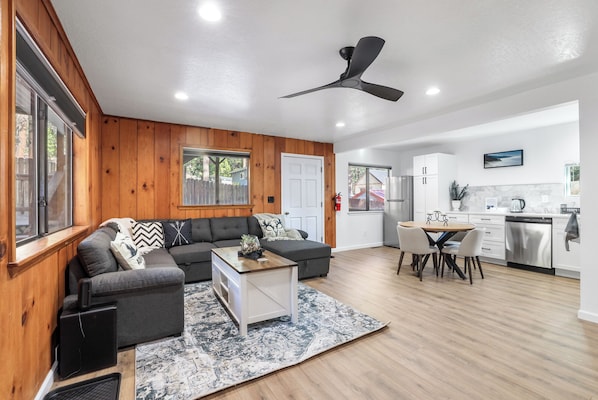 A modern living room with a sofa, coffee table, and dining area.
