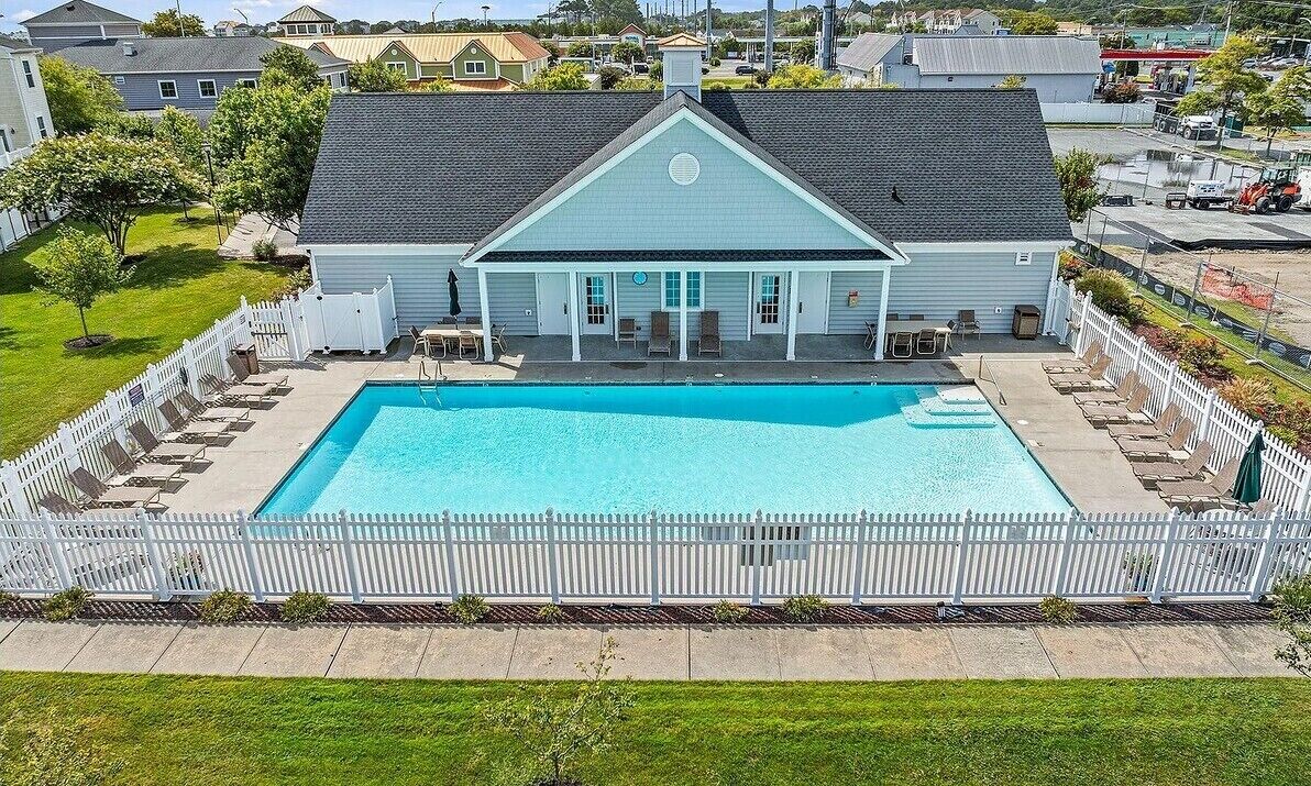 Ein Wohnhaus mit Schwimmbad, umzäunter Garten und einem Satteldach.