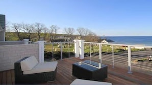 Un balcon avec coin salon extérieur, une vue sur la mer et un espace de stationnement.