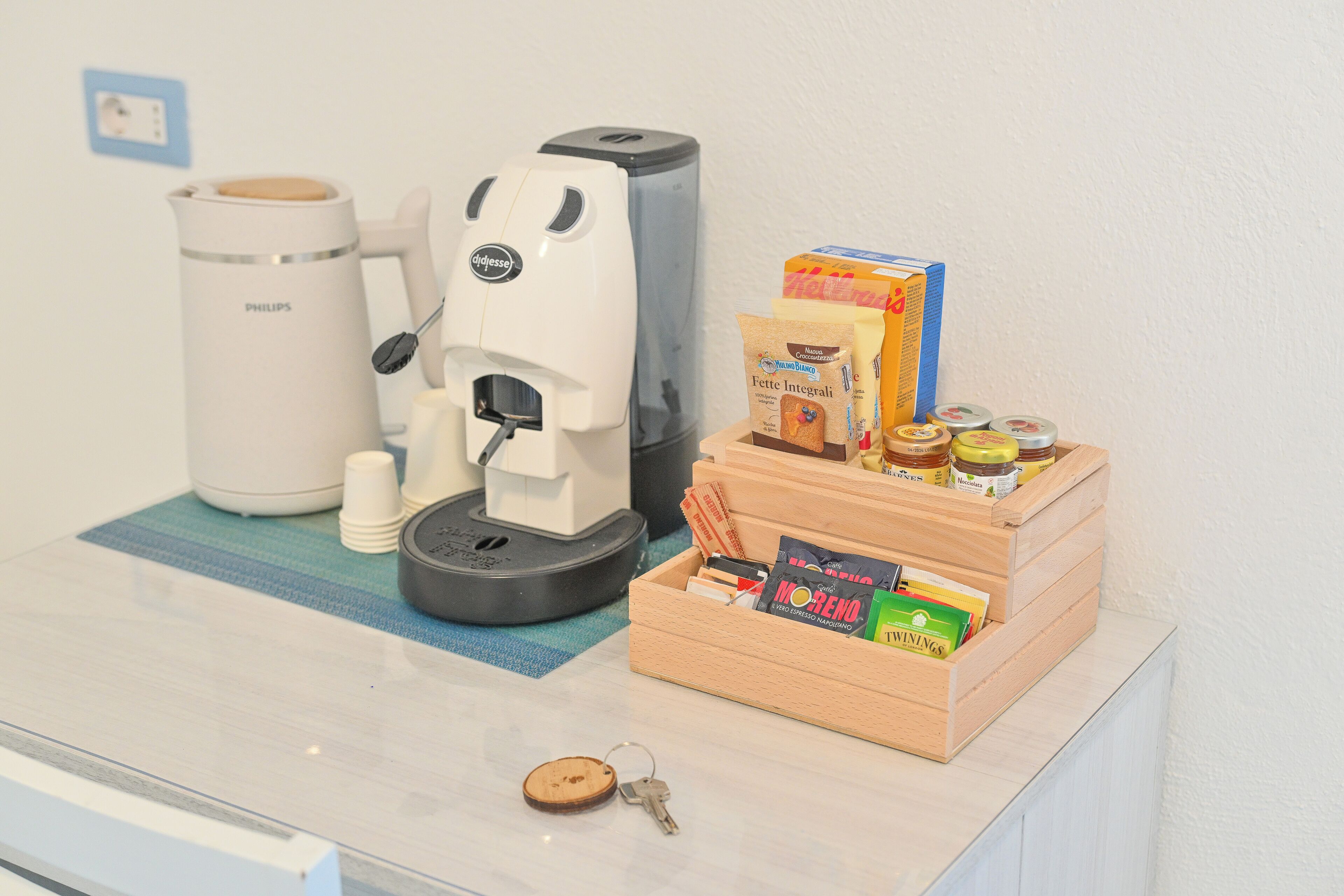 Una cafetera, una bandeja con alimentos y un juego de llaves sobre una encimera.