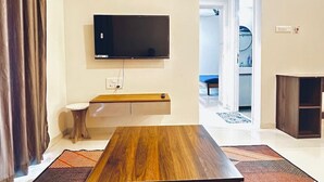 Una sala de estar moderna con una mesa de centro de madera, un televisor de pantalla plana montado en la pared y un estante empotrado.