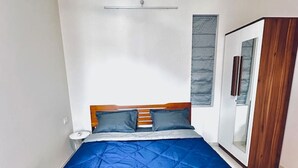 Un dormitorio con cama, armario y ventana con persianas.