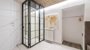 Una stanza con una porta scorrevole in vetro, un termosifone e una mappa del mondo appesa al muro.