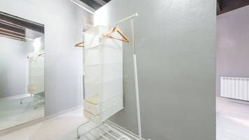 A room with a white wardrobe, a mirror, and a radiator.