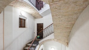 Un intérieur à plusieurs niveaux, avec un escalier, une porte et une fenêtre.