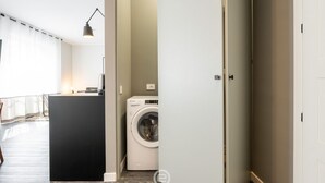 A modern apartment with a laundry area, a small kitchen, and a view of the living area. - Saint Margaret Apartments - Olivia (Cagliari)