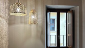 Une chambre avec deux lits, un plafond en bois et une fenêtre dont le volet est ouvert.