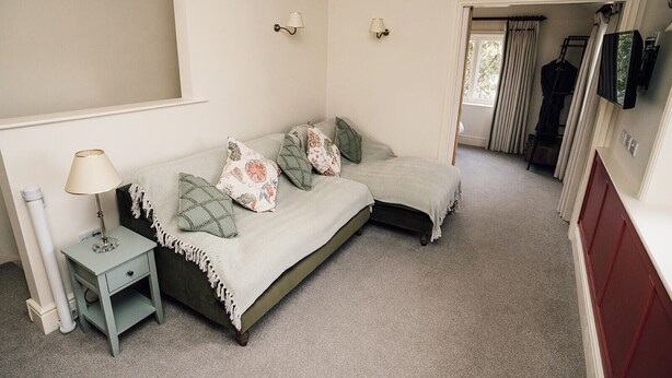 A bedroom with a bed, bedside table, lamp, and a wardrobe. - Luxury Farm Cottage with Hot Tub in Yorkshire (Northallerton)