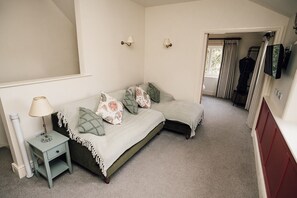 A bedroom with a bed, bedside table, lamp, and a wardrobe.