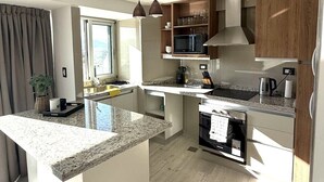 Una cocina moderna con encimeras de granito, armarios de madera y un microondas integrado.