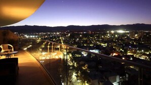 Un balcón con vistas a un paisaje urbano al anochecer.