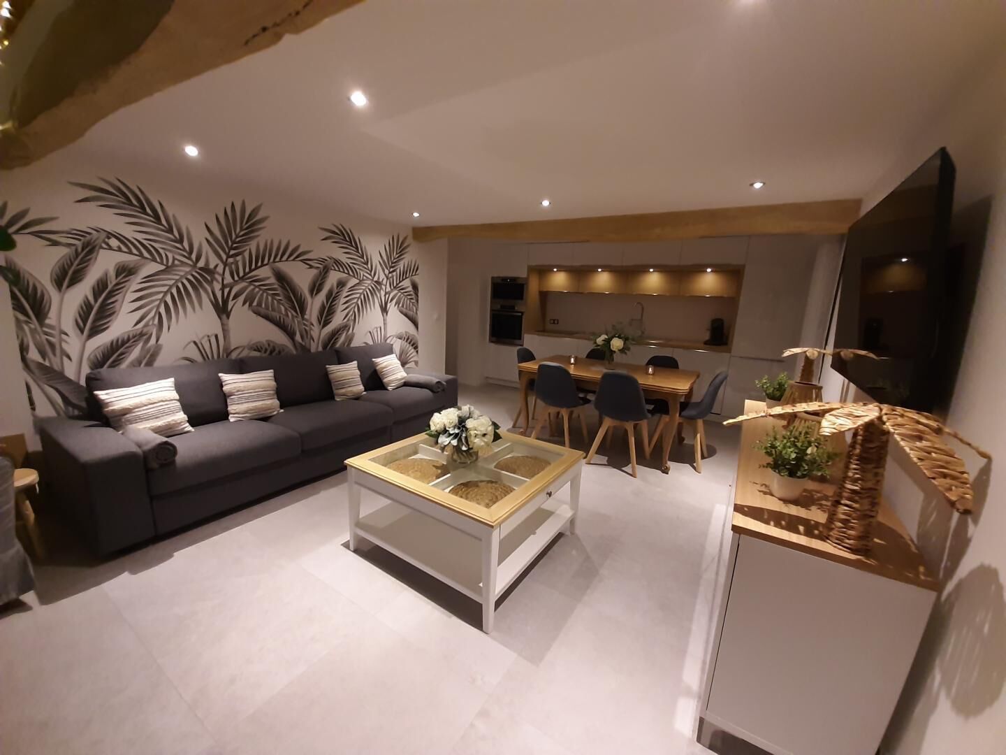 A modern living room with a sofa, coffee table, and dining area.