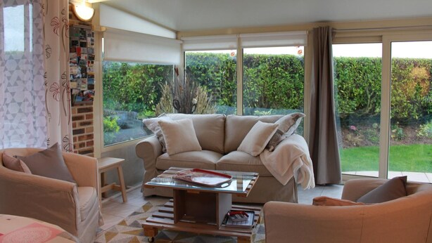 A cozy living room with a beige sofa, a coffee table, and a bookshelf. - Gîtes de France® - Auleclairlogis (ETAINHUS)