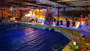 Uma área de piscina com árvore de Natal e decoração festiva.