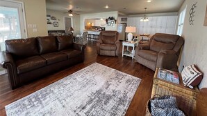 A living room with a brown leather sofa, two armchairs, a coffee table, and a patterned rug. - Porch, Paddle & Stay on PK - East side close to Rocker B Ranch (Graford)