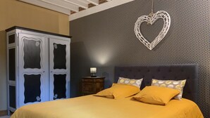 Ein Schlafzimmer mit einem Bett, einem Kleiderschrank und einer Wand mit Herz-Dekoration.