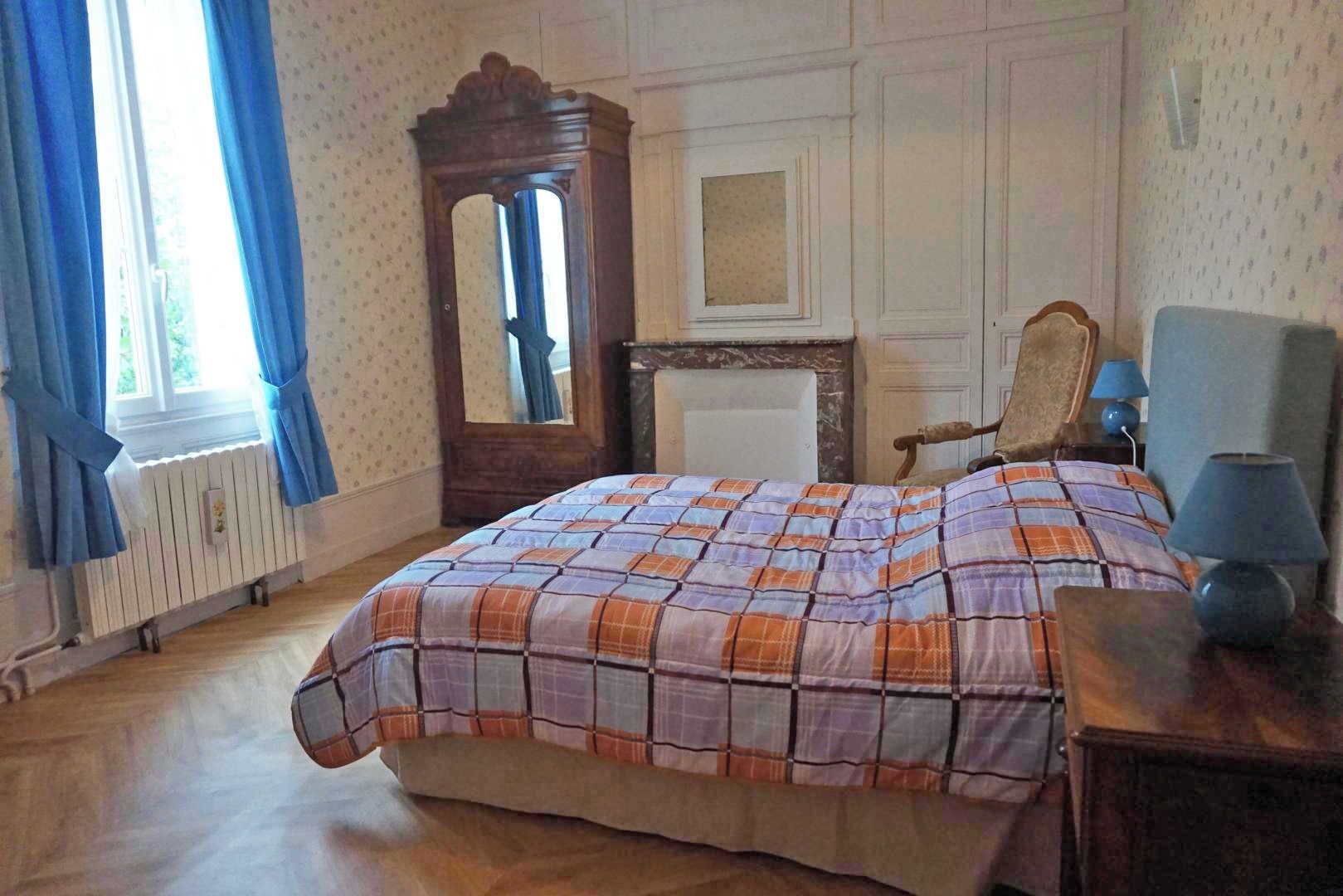 Une chambre à coucher avec un lit, une commode, une chaise et un miroir.
