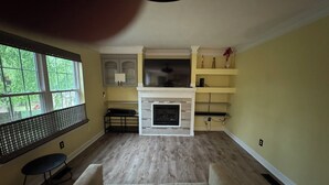 Ein Wohnzimmer mit Kamin, einer Couch und einem Essbereich mit Tisch und Stühlen.